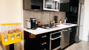 a kitchen with a stove and a refrigerator at LUXURY Downtown Sunset Getaway - Your Home Away From Home - Fully Stocked Kitchen, Gym, Balcony, FREE PARKING in Calgary