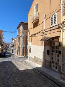 una calle vacía con un edificio y un balcón en La casetta della zia Nina, en Santo Stefano di Camastra
