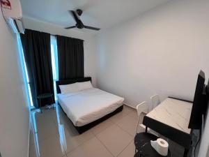 um pequeno quarto com uma cama e uma mesa em METROPOL SERVICED APARTMENT at Bukit Mertajam, Pulau Pinang em Bukit Mertajam
