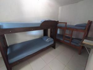 a room with two bunk beds and a table at Chalé Brisa do Mar in Santa Cruz Cabrália