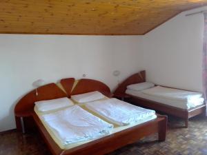 a bedroom with two beds and a wooden ceiling at Penzion Palma in Sečovlje