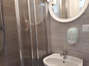 La salle de bains est pourvue d'une douche, d'un lavabo et d'un miroir. dans l'établissement Hotel Villa Mon Reve, à Rimini