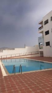 a swimming pool in front of a building at House of banana beach aourir in Aourir