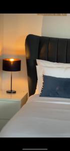 a bed with a blue pillow and a lamp on a night stand at Modern Luxury Flat in Putney in London