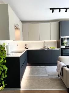 a kitchen with black and white cabinets and a sink at Modern Luxury Flat in Putney in London