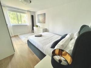 a bedroom with a bed and a couch and a window at Modern Luxury Flat in Putney in London
