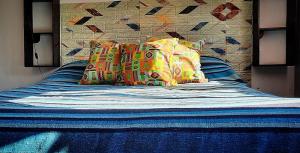 a bed with colorful pillows on top of it at D' Charrúas Hostel Concordia in Concordia