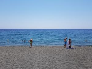 a group of people on a beach near the water at Ioanna's Villa 10 minutes walking from sea in Gra Liyiá