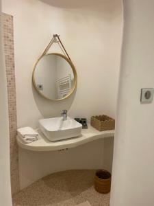 La salle de bains est pourvue d'un lavabo et d'un miroir. dans l'établissement CHAMBRE D HOTE, à Porticcio