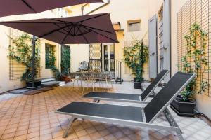 - une terrasse avec 2 bancs et un parasol dans l'établissement Fossalta Home, in the heart of the Historical Center, à Bologne