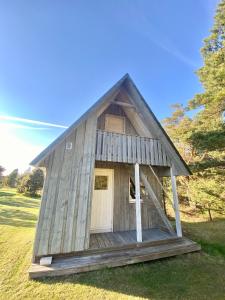 a small wooden house with a pitched roof at Männiliiva puhkemaja in Hiiumaa
