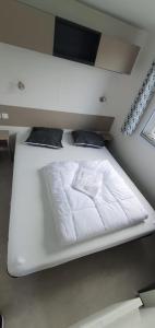 レ・マトゥにあるMobil Homeのテレビ付きの客室の白いベッド1台