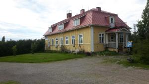 uma grande casa amarela com um telhado vermelho em Asemansaunatupa em Pyhäjärvi