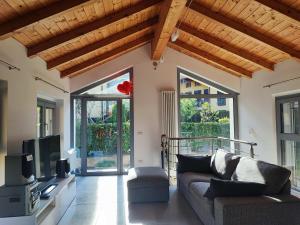 a living room with a couch and a tv at Olia House in Olginate