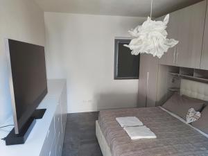 1 dormitorio con 1 cama con TV y lámpara de araña en Olia House, en Olginate