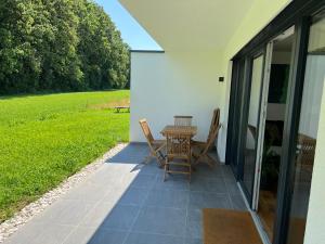 eine Terrasse mit einem Tisch und Stühlen an der Seite eines Hauses in der Unterkunft PR Arpartment in Lenzing