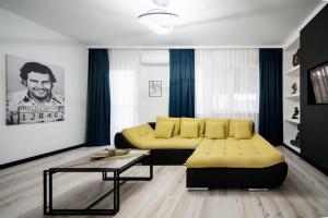 a living room with a yellow couch and a table at Backyard Jacuzzi House in Oradea