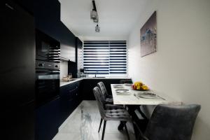 a kitchen with a small table and chairs in a room at Backyard Jacuzzi House in Oradea