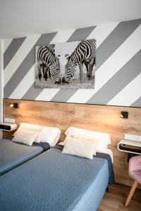 two zebras painting on a wall in a bedroom at Hotel Ridomar 365 in Lloret de Mar