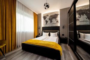 a bedroom with a bed with a yellow blanket on it at Backyard Jacuzzi House in Oradea