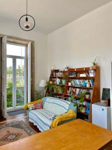 a living room with a couch and a book shelf at Casa dos Caminhos de Santiago in Mosteiró