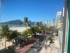 una calle de la ciudad con palmeras y una playa en APTO. BEIRA MAR EM BAL. CAMBORIU, en Balneário Camboriú