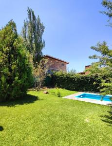 a yard with a swimming pool in front of a house at Casa Huellas de Malbec - Montaña y paz in Las Compuertas