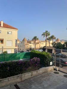 uma cerca com flores roxas em frente a um edifício em Casa Kizkur em Tarifa