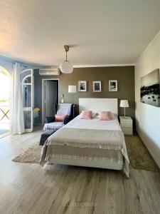 ein Schlafzimmer mit einem großen Bett und einem Sofa in der Unterkunft Sweet Home Chill Out Studio in Tavira