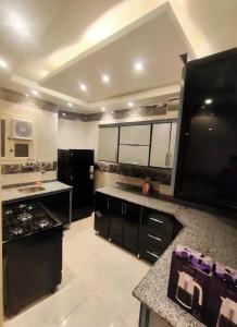 une cuisine avec des armoires en noir et blanc et un comptoir dans l'établissement African Shield Company, au Caire