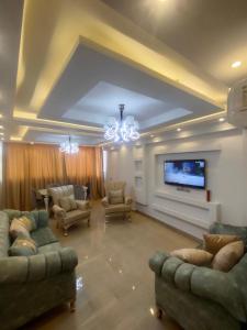 Il comprend un salon avec des canapés et une télévision à écran plat. dans l'établissement African Shield Company, au Caire