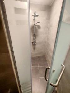 La salle de bains est pourvue d'une douche avec une porte en verre. dans l'établissement African Shield Company, au Caire