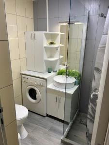 a bathroom with a toilet and a washing machine at Gallery City Center Apartment in Skopje +21 photos