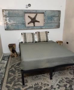 łóżko w pokoju z rozgwiazdą na ścianie w obiekcie San MARTÍN w mieście Cozumel