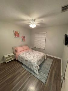 a bedroom with a bed with a pink comforter at Beautiful single story 4 br. home in nice area. in Palmdale