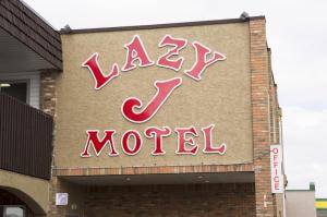 a sign that is on the side of a building at Lazy J Motel in Claresholm