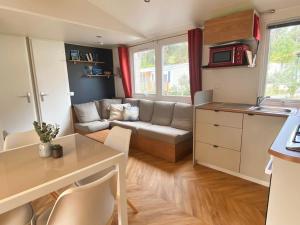ein kleines Wohnzimmer mit einem Sofa und einem Tisch in der Unterkunft MOBIL HOME 6 personnes Cap Ferret in Lège-Cap-Ferret