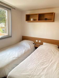 - 2 lits blancs dans une chambre avec fenêtre dans l'établissement MOBIL HOME 6 personnes Cap Ferret, à Lège-Cap-Ferret