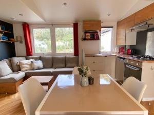 a kitchen and living room with a table and a couch at MOBIL HOME 6 personnes Cap Ferret in Lège-Cap-Ferret