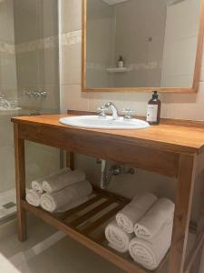 La salle de bains est pourvue d'un lavabo et de serviettes. dans l'établissement Villa Maihue departamentos de montaña - Caviahue, à Caviahue