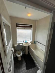 6 Bed 6 Bath House Fantastic for contractors & Groups في لوتون: حمام مع مرحاض وحوض استحمام ومغسلة