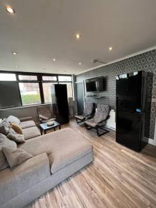 a large living room with a couch and a kitchen at 6 Bed 6 Bath House Fantastic for contractors & Groups in Luton