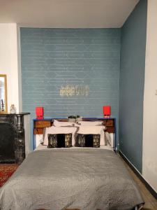 - une chambre avec un grand lit et un mur bleu dans l'établissement Studio Séquoia au pied du Château, à Saumur