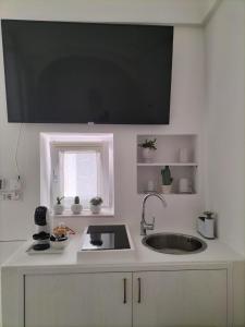 a white kitchen with a sink and a window at Dimore di Gio' Luxury Private Wellness Spa in Ostuni