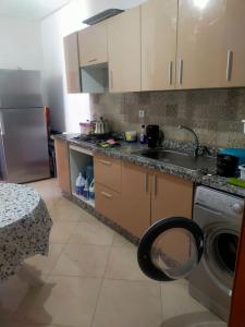 a kitchen with a sink and a washing machine at Appt a 500 m de la plage in Douar Ourlali