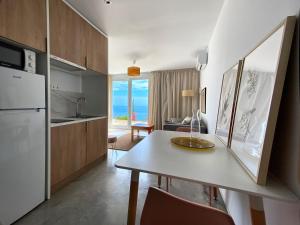 a kitchen and living room with a table and a refrigerator at La Paratá Suites Mojácar in Mojácar