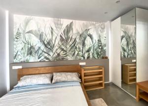 a bedroom with a large mural of plants on the wall at La Paratá Suites Mojácar in Mojácar +112 photos