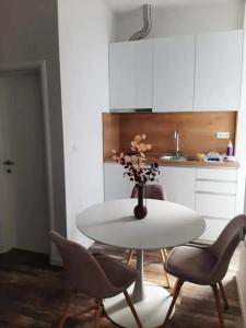 a white table with chairs and a vase with flowers at Studio apartman Mara in Imotski