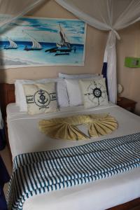 a bed in a room with a painting on the wall at Driftwood Beach Lodge in Jambiani