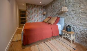 a bedroom with a bed and a stone wall at Château beyrin 